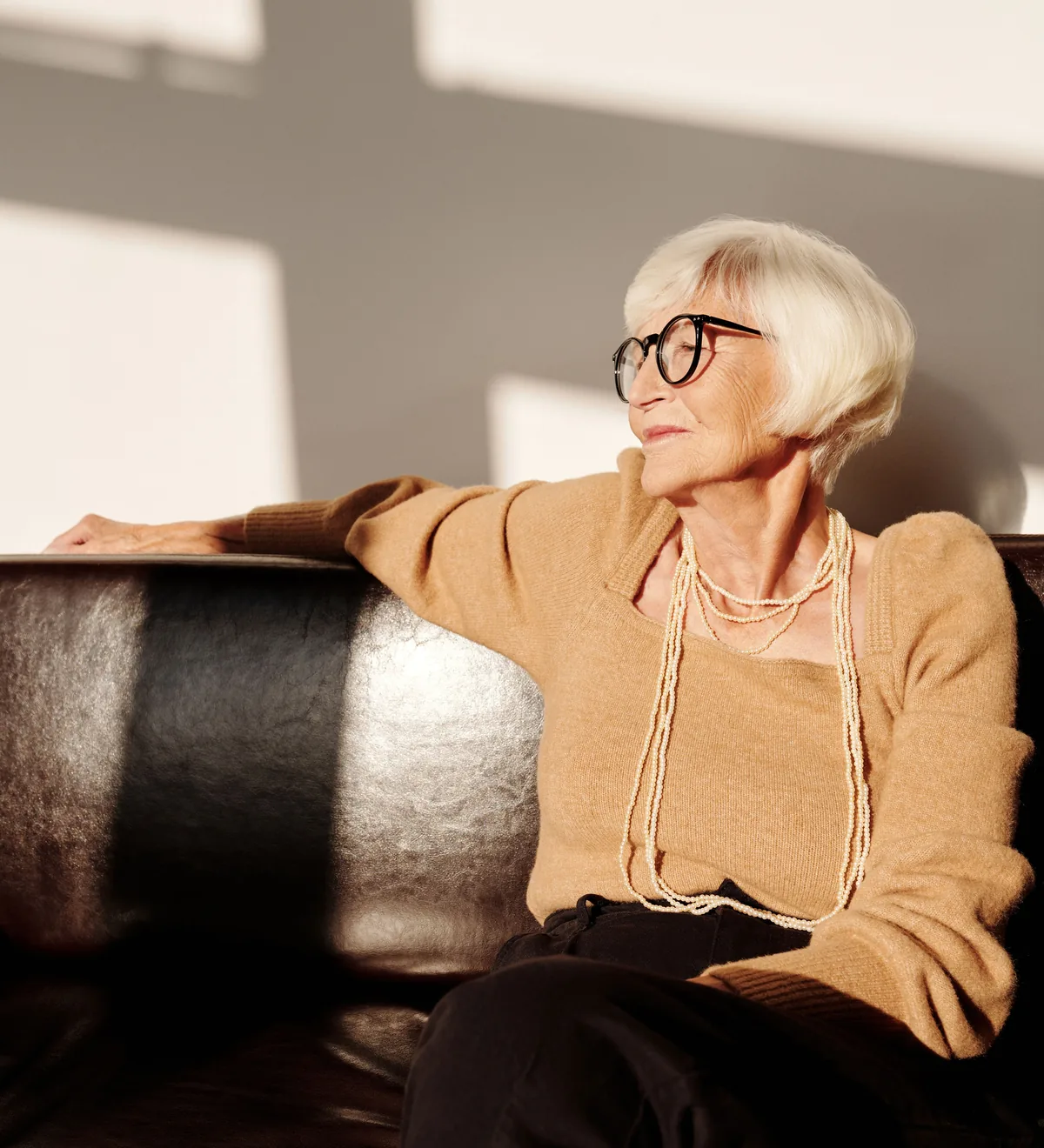 A woman in her seventies sitting in afternoon light at home
