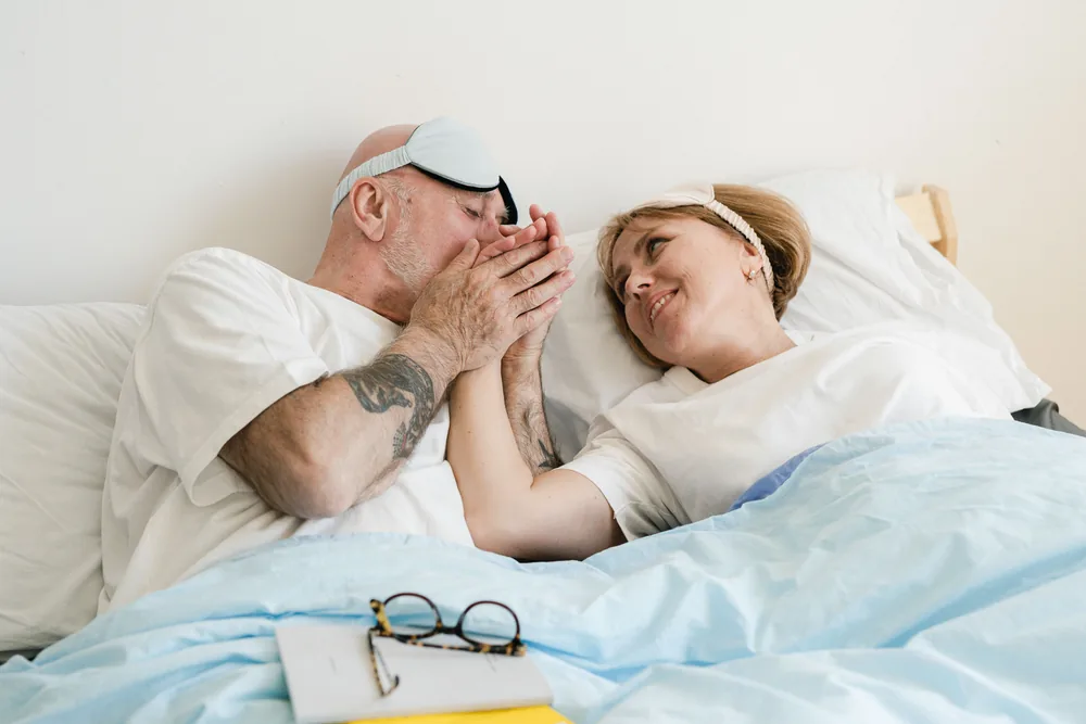 A man waking rested in a sunlit bedroom
